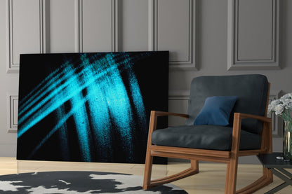 Blue Lights Glass Wall Art displayed in modern living room with wooden chair, showing cyan diagonal light streaks on black background.