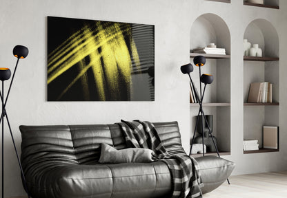 Yellow Lights Glass Wall Art displayed above a black leather sofa in a modern living room with built-in shelving.