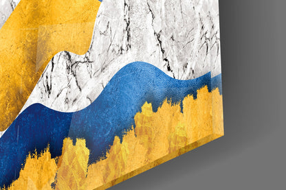 Angled view of glass wall art featuring layered mountains in blue, yellow, and white with textured surface detail.