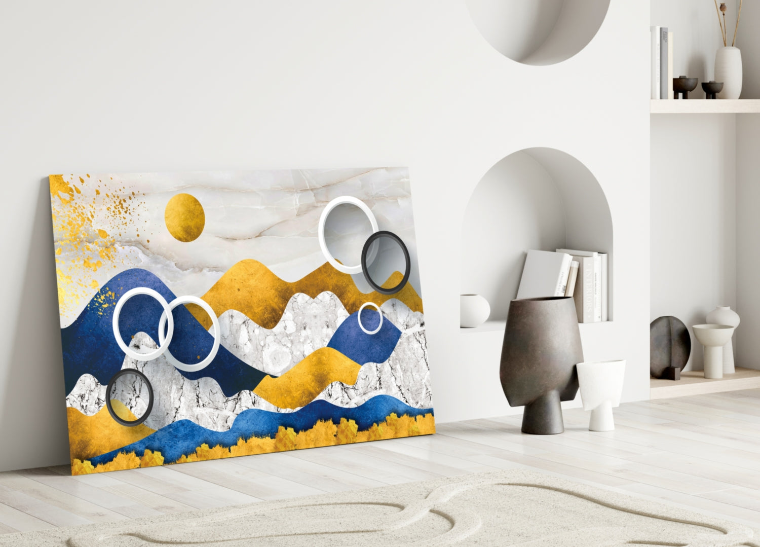 Colorful Mountains Glass Wall Art leaning against white wall in minimalist room setting with decorative objects and shelving.