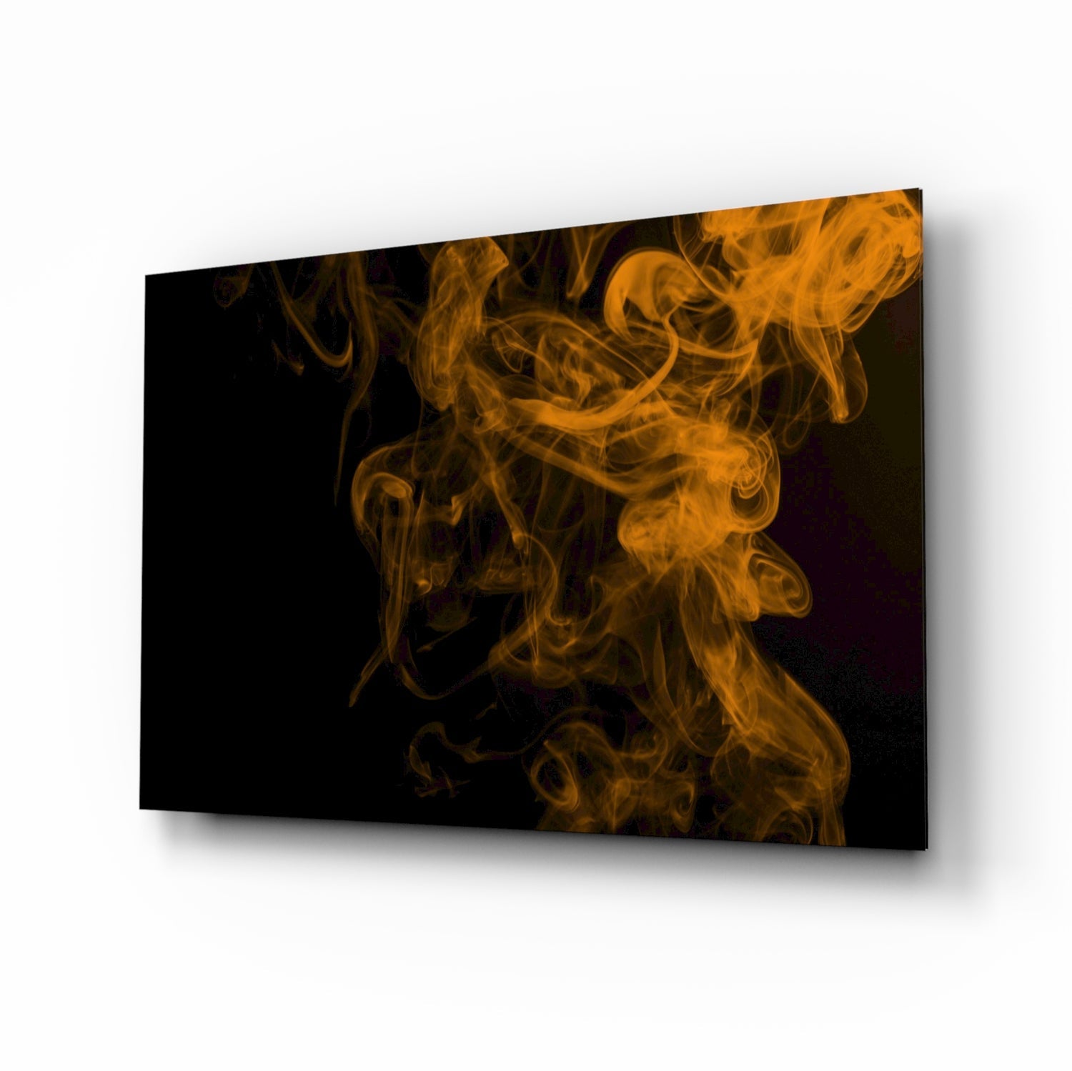 Angled perspective view of glass wall art displaying swirling orange and golden smoke patterns against a black background.