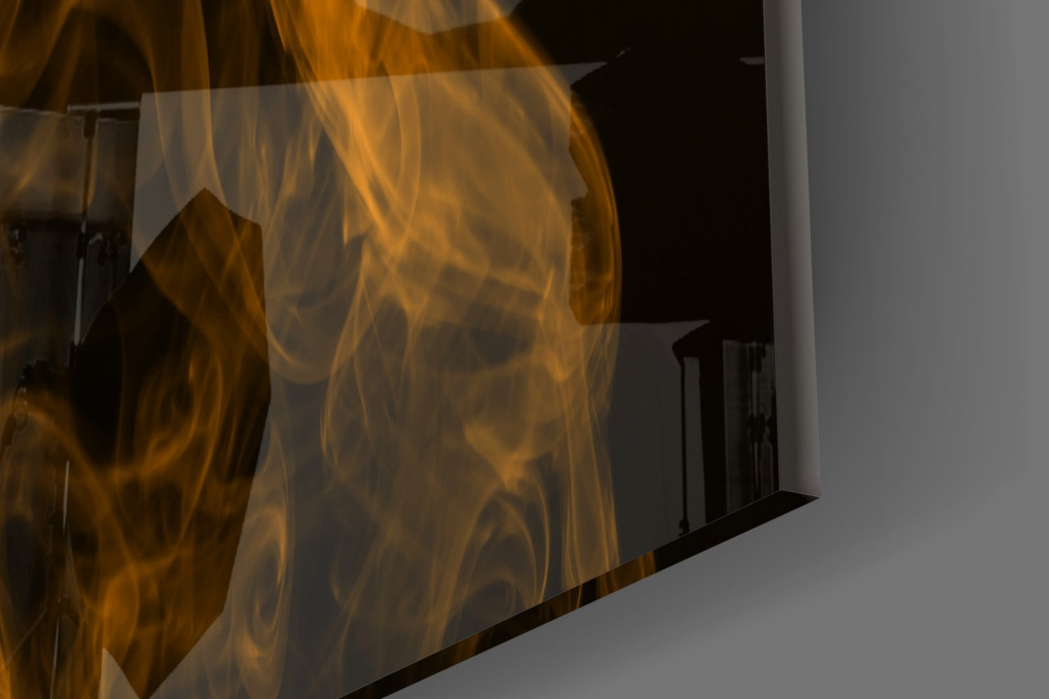 Close-up angled view of translucent orange smoke glass wall art panel with swirling amber and gold patterns against gray background.