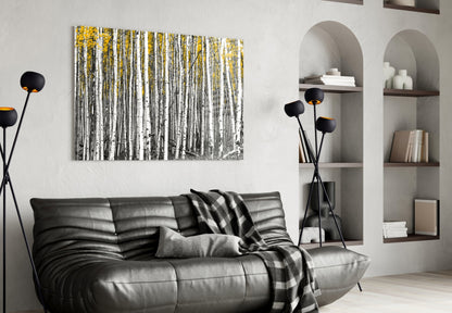 Yellow Forest glass wall art displaying birch trees with white trunks and golden foliage above a black leather sofa in a modern living room.