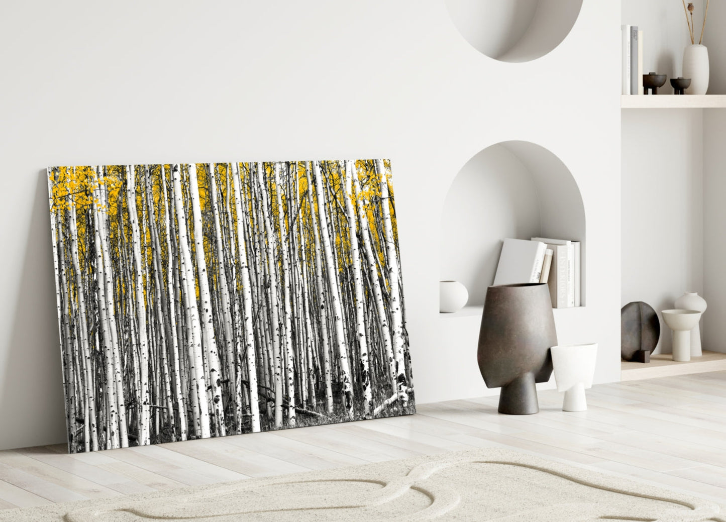 Yellow Forest Glass Wall Art leaning against white wall in minimalist room with sand and sculptural decor.