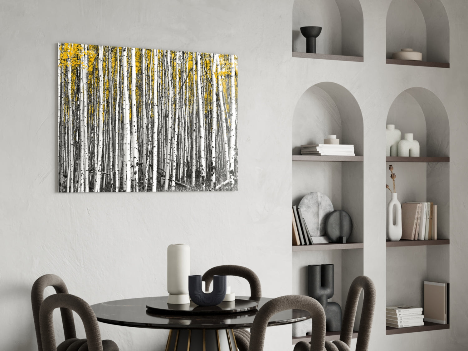 Yellow Forest glass wall art displayed above a round black dining table with grey upholstered chairs in a modern interior setting.