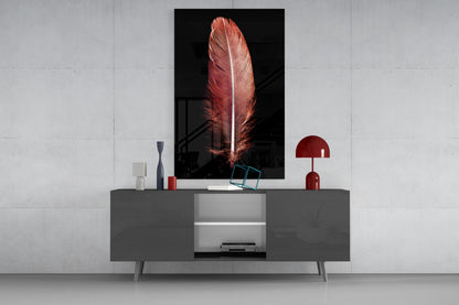 Red feather glass wall art displayed above gray media console with decorative items in modern living room setting.
