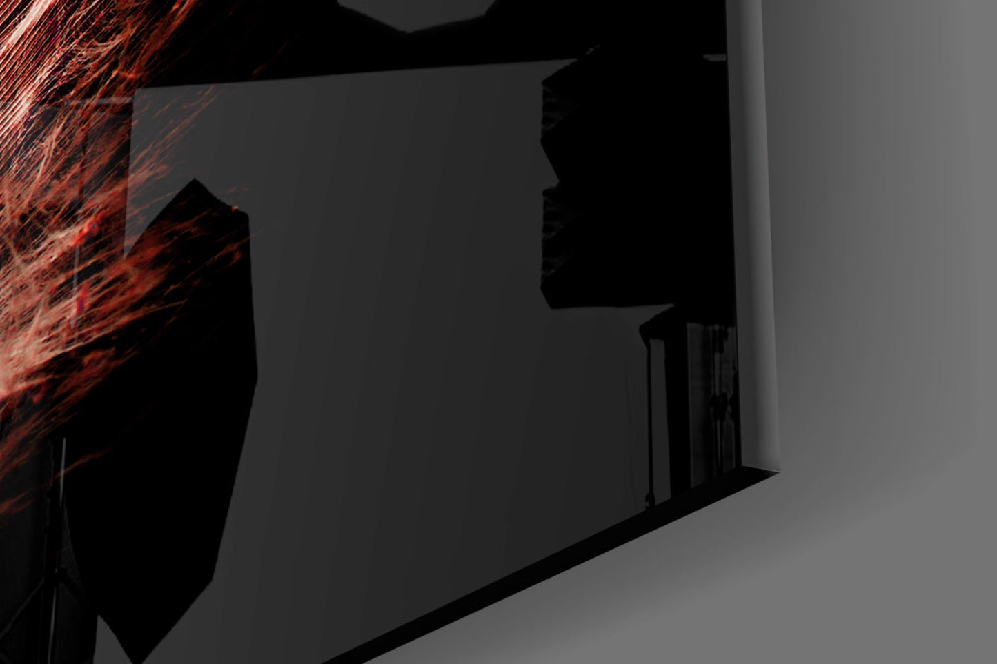 Close-up angled view of Tile Feather Glass Wall Art showing red and black feather design against gray architectural background.