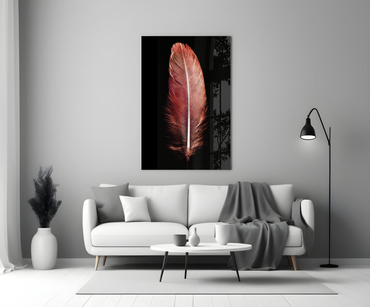 Red feather with white center vein displayed as glass wall art above white sofa in modern living room setting.