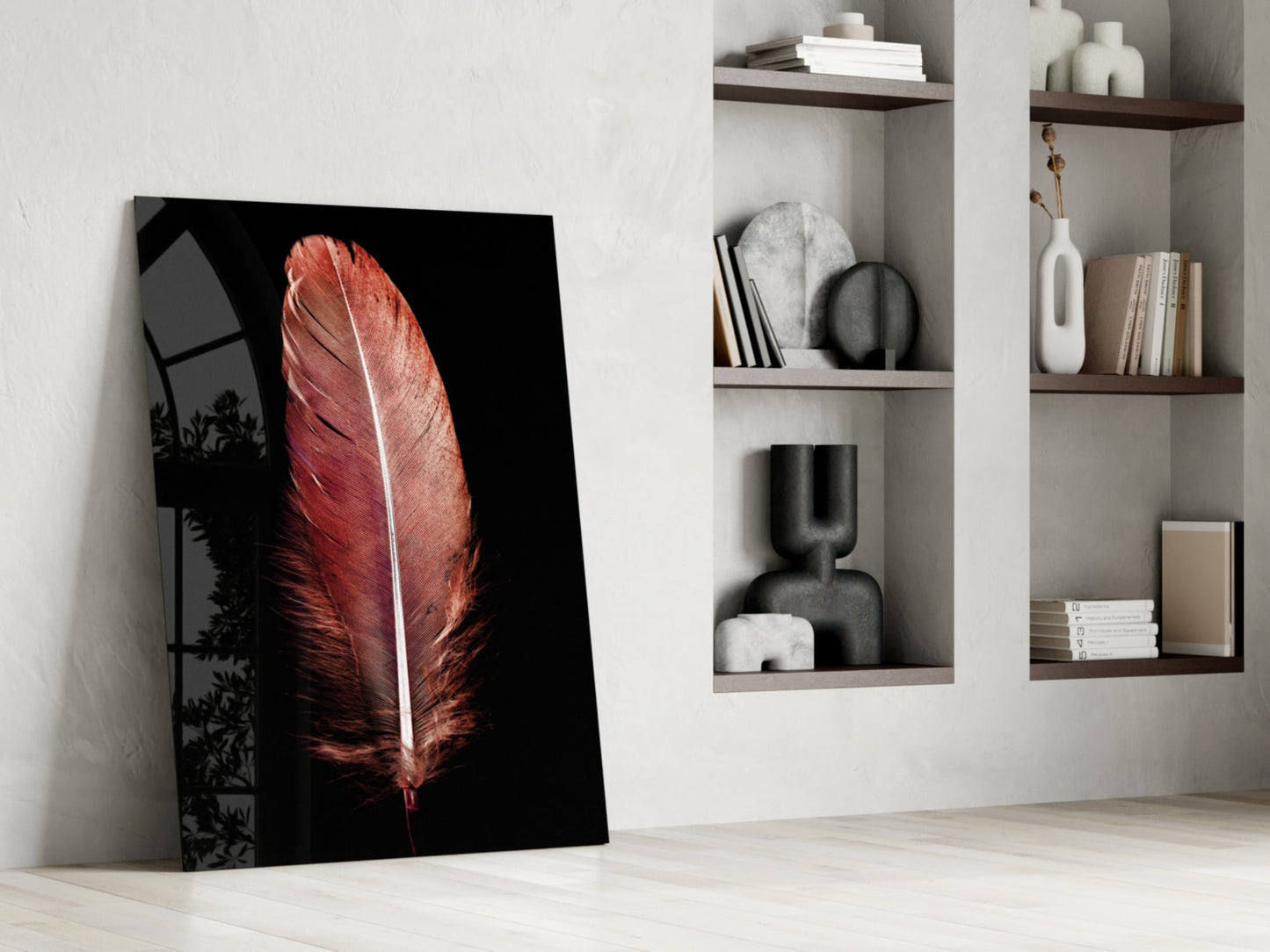 Red feather glass tile leaning against white wall beside shelving with decorative objects and books.