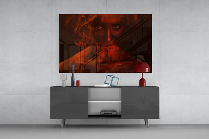 Red smoke and woman glass wall art displayed above gray media console with decorative accessories in modern living room setting.