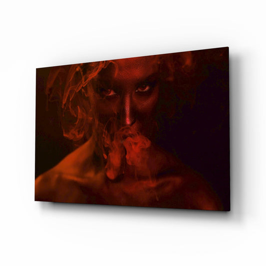 Glass wall art panel displaying a woman's face emerging from red smoke against a dark background, mounted at an angle.