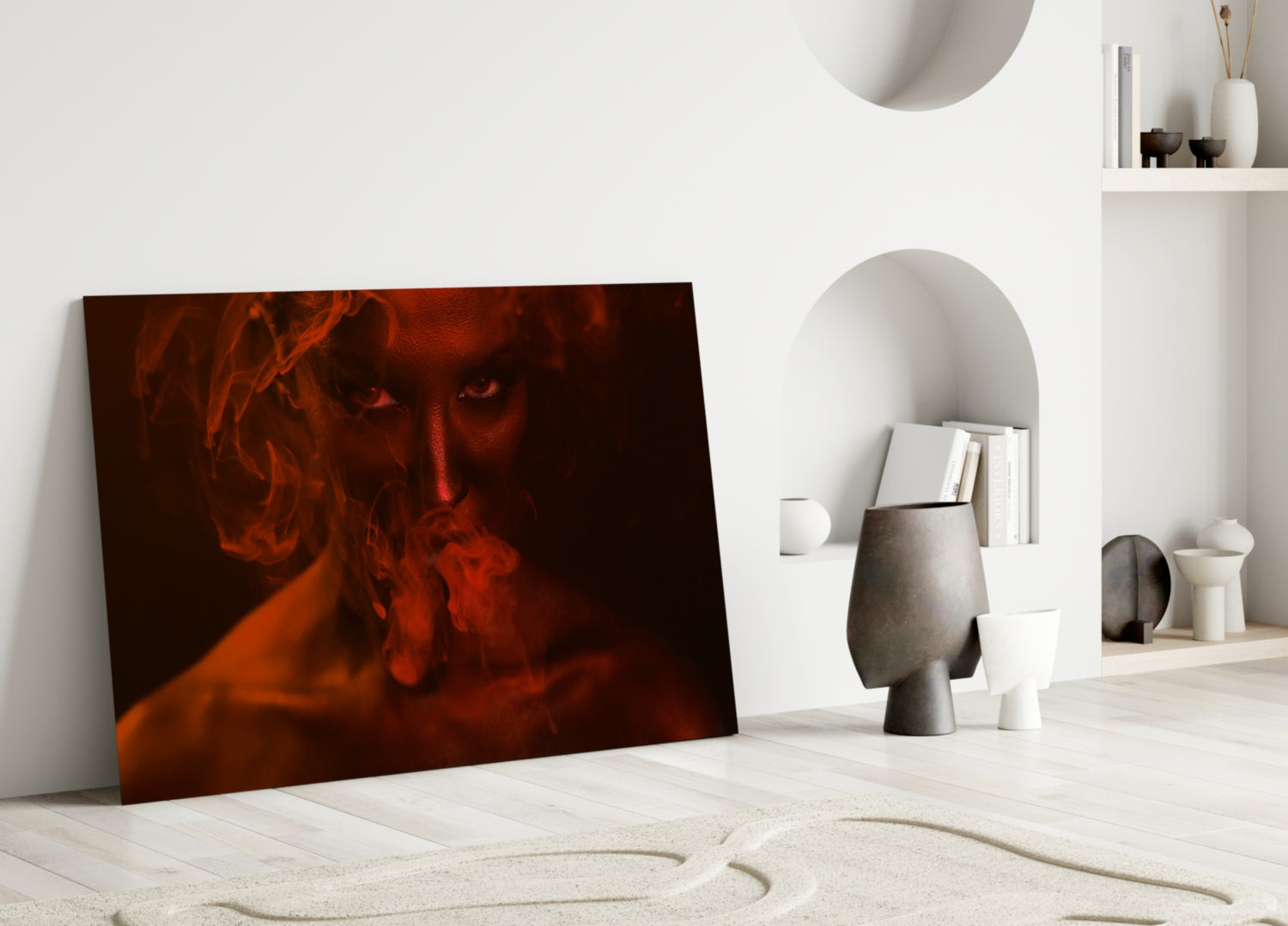 Red and orange toned glass art leaning against white wall in minimalist interior with sculptural decor and shelving.