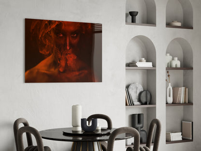 Red and orange toned glass art depicting a woman's face displayed above a black dining table in a modern interior setting.