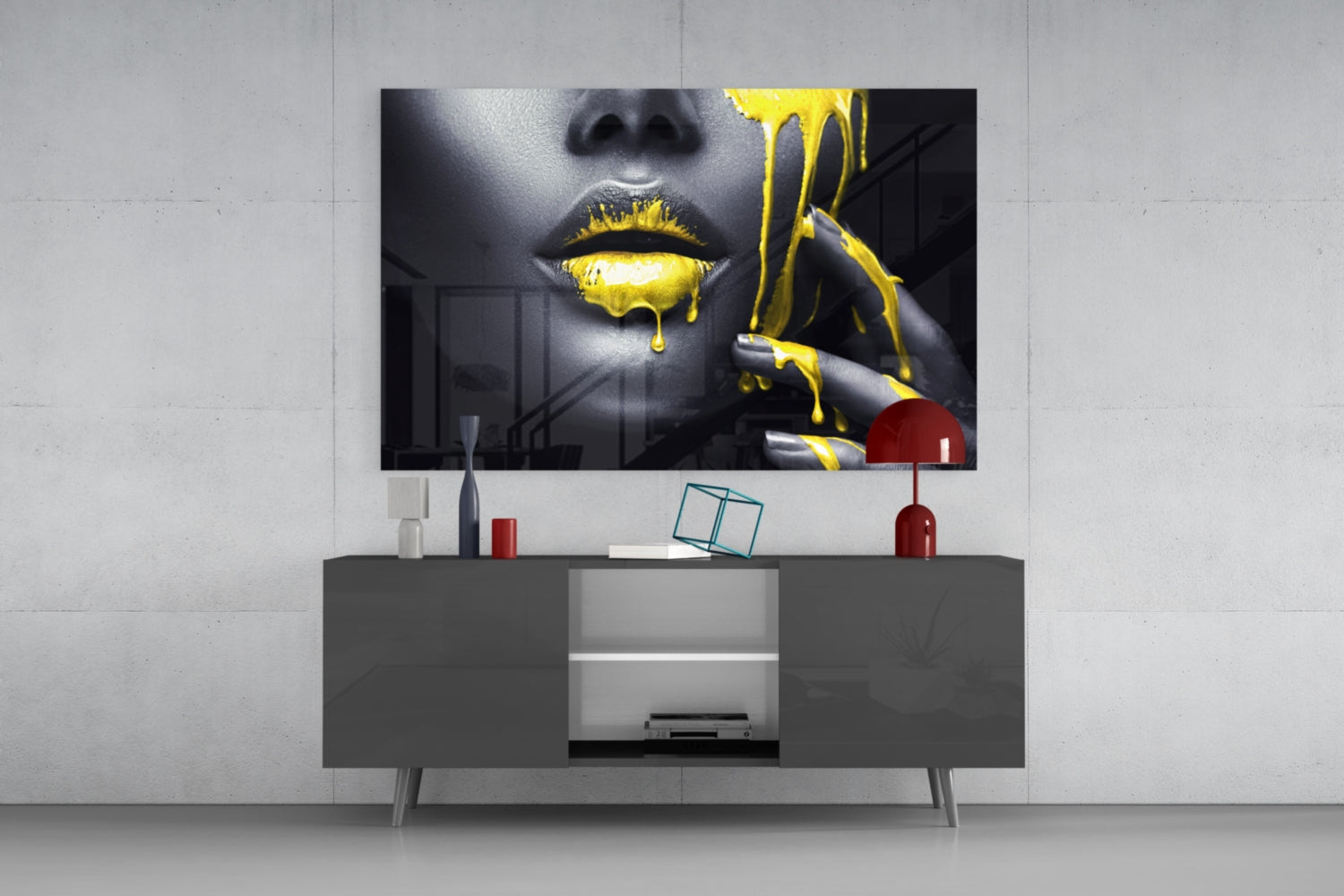 Modern living room setup with mounted glass wall art featuring a woman's face with yellow dripping paint effect above a gray media console.