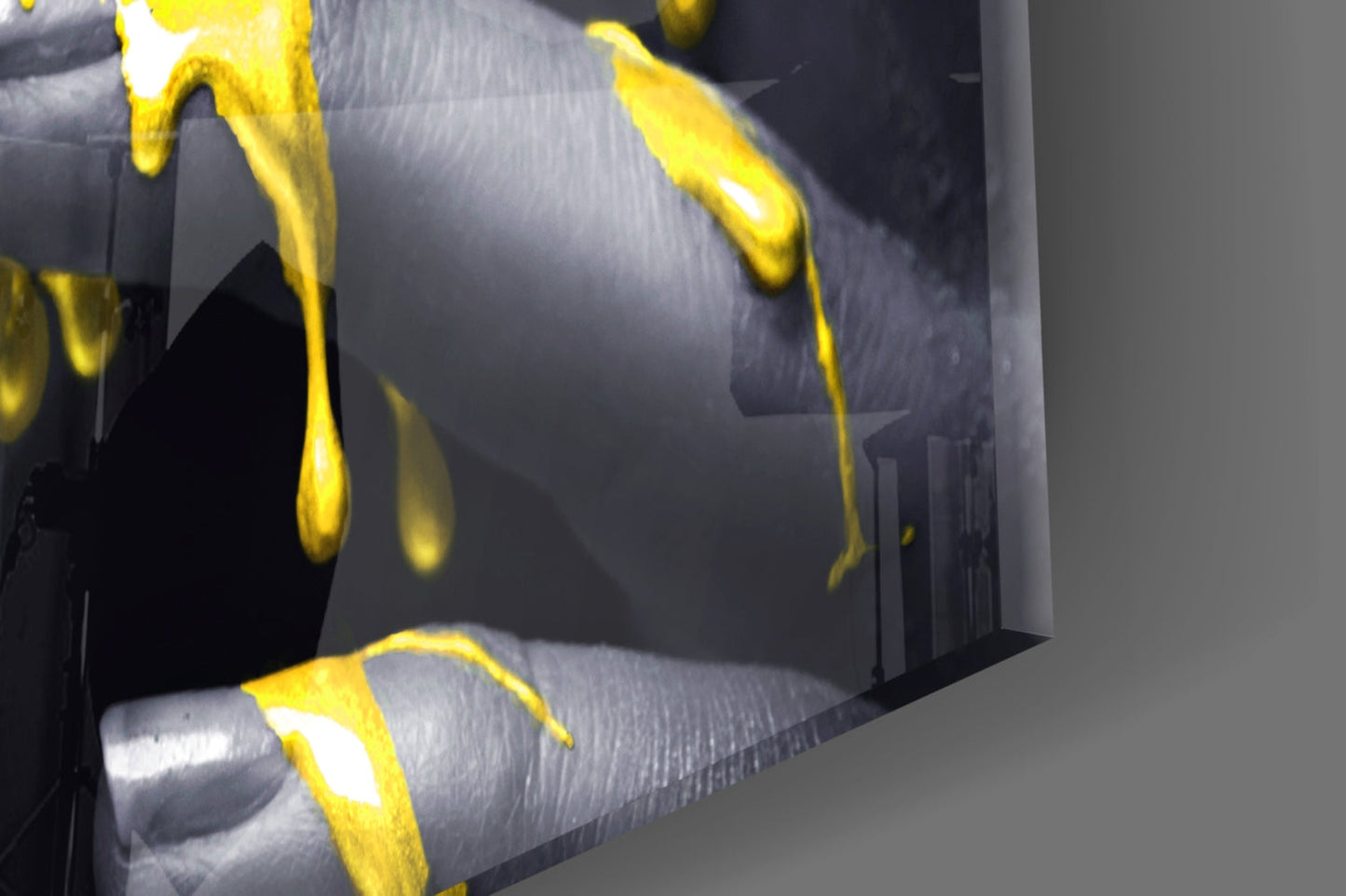 Close-up angled view of yellow glass petals against gray textured background on wall art panel.