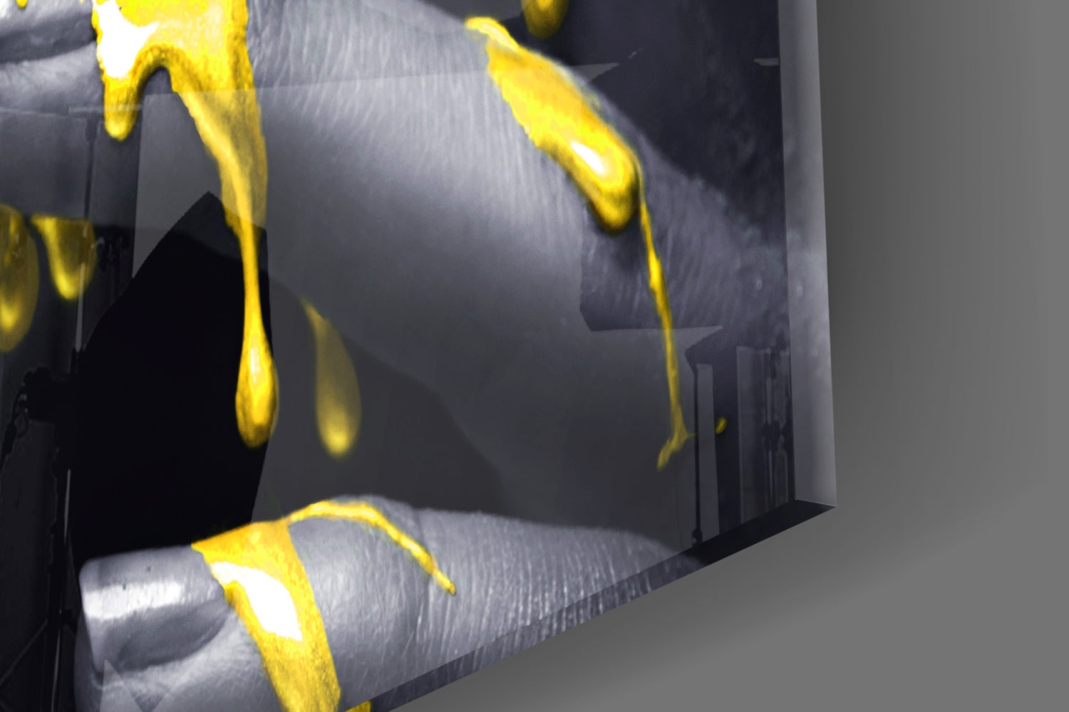 Close-up angled view of yellow glass petals against gray textured background on wall art panel.
