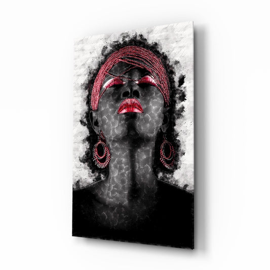 Mounted glass wall art displaying a grayscale portrait of a woman wearing a red headwrap and earrings, with red-accented eyes and lips, surrounded by black ink splatters.