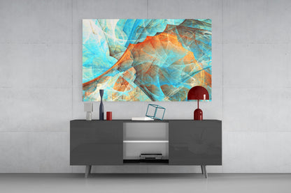 Abstract glass wall art with layered blue, orange, and turquoise geometric patterns displayed above a dark gray media console in a modern interior setting.