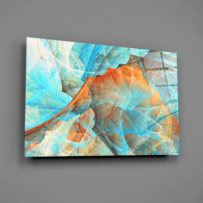 Angled view of glass wall art displaying layered turquoise and orange geometric patterns with translucent overlapping shapes.