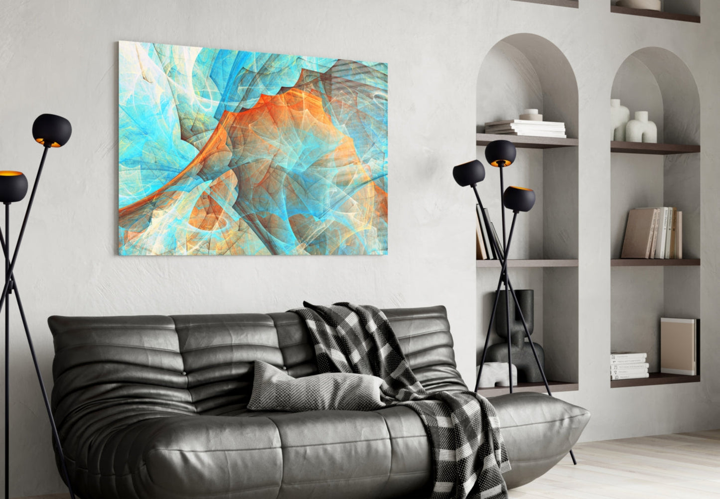 Modern living room with turquoise and orange abstract glass art above black leather sofa beside white shelving.