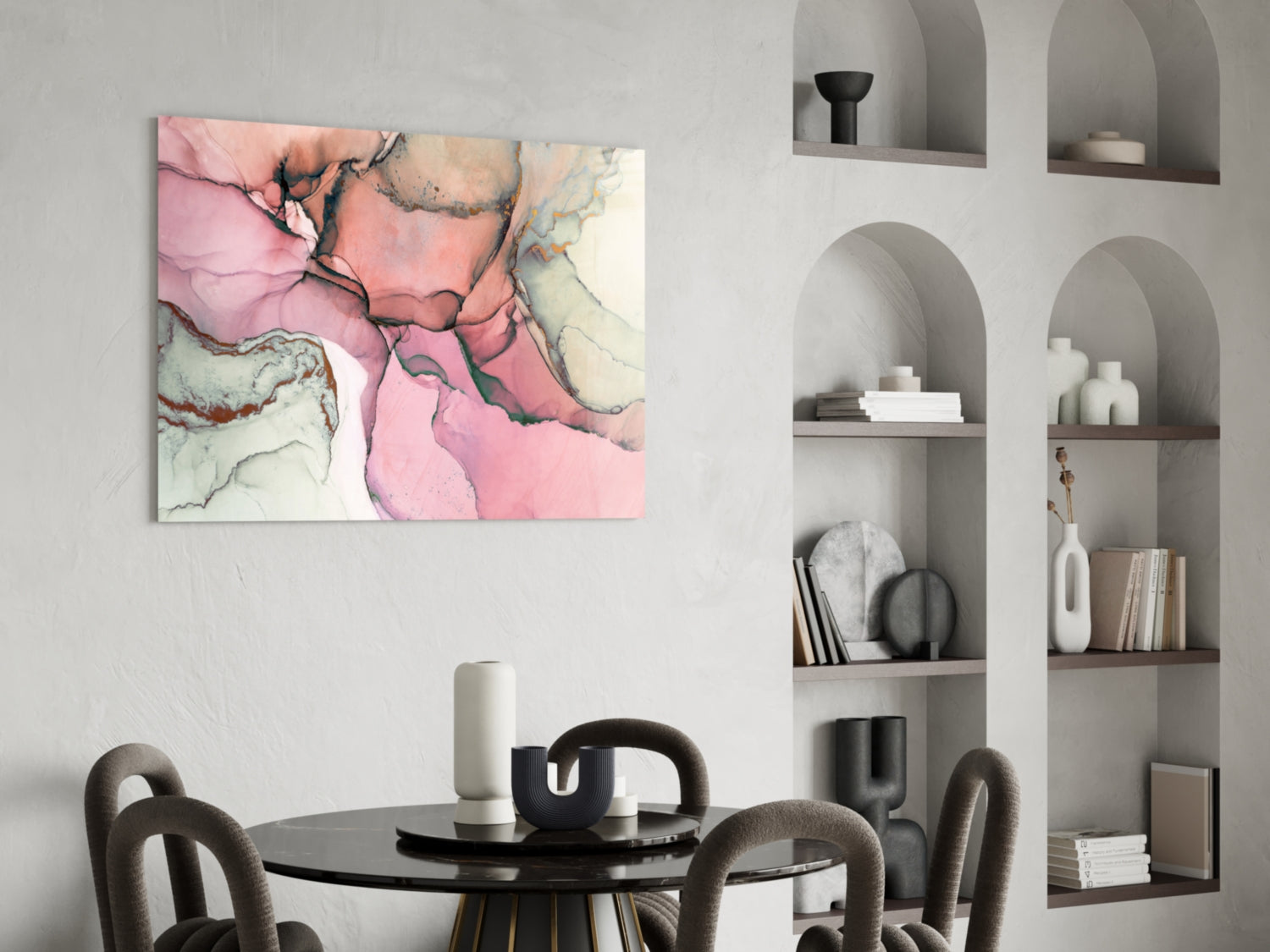Pink and cream marbled glass wall art hung above a black dining table in a modern interior with built-in shelving.