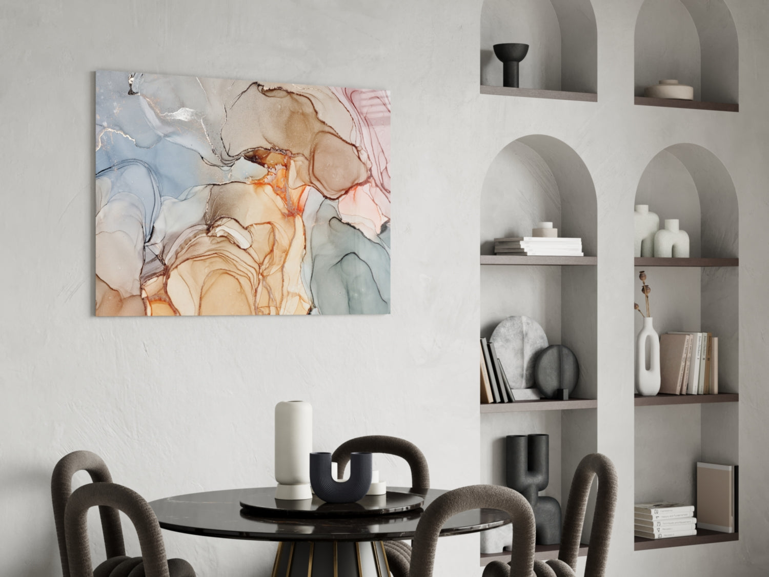 Abstract glass wall art with soft blue, pink, orange and beige marble patterns displayed above a round black dining table with upholstered chairs.
