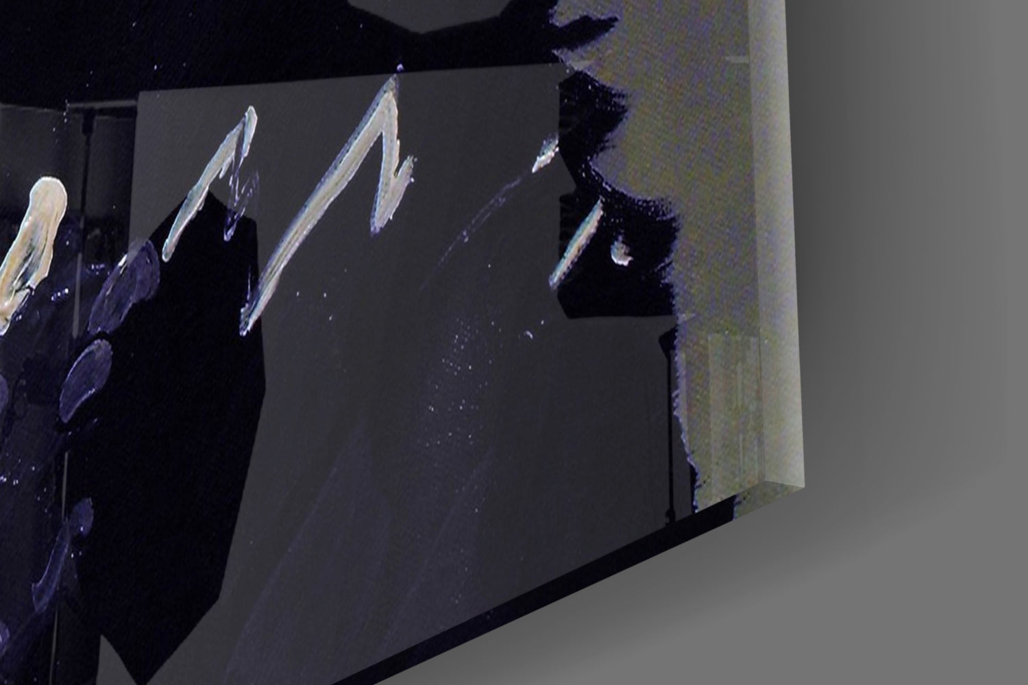 Close-up angled view of glass wall art showing white brushstroke designs on dark surface with gray mounting area.