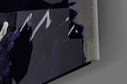 Close-up angled view of glass wall art showing white brushstroke designs on dark surface with gray mounting area.