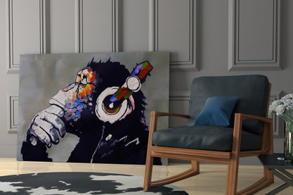 Colorful glass wall art of a black chimp wearing headphones displayed in a modern living room next to a wooden chair.