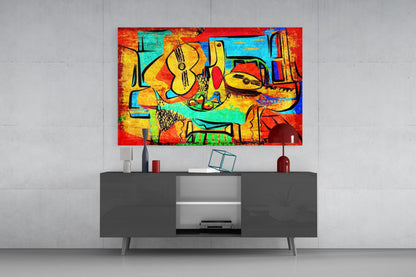 Colorful abstract glass wall art featuring musical instruments and vibrant reds, yellows, and blues displayed above a dark media console.