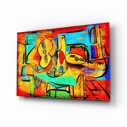 Colorful abstract glass wall art featuring yellow cellos and musical instruments against vibrant red, blue, turquoise, and orange geometric backgrounds, displayed at an angle.