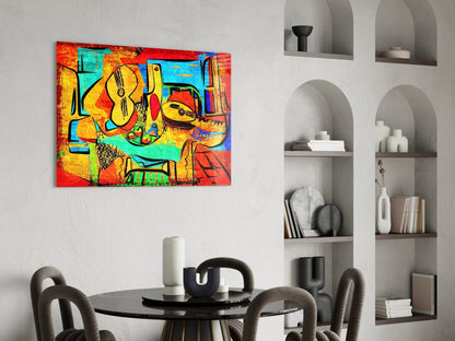 Vibrant abstract cello glass wall art in red, yellow, turquoise, and black displayed above a black dining table in a modern interior.