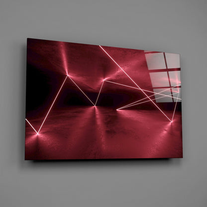 Red neon geometric lines forming triangular patterns on dark crimson glass panel mounted on gray wall.