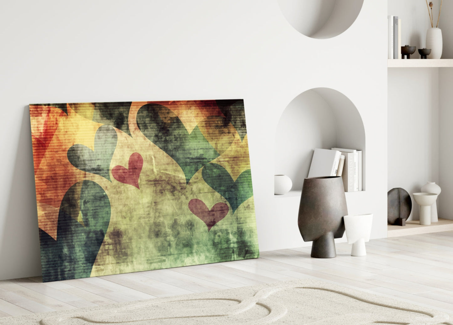 Colorful glass wall art leaning against white wall displays green cactus shapes with red hearts on warm yellow and orange background.