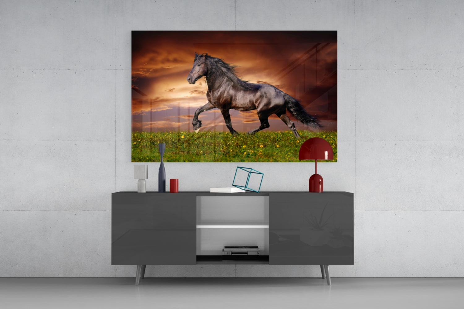 Black horse galloping across green field at sunset, displayed as framed glass art above gray media console.