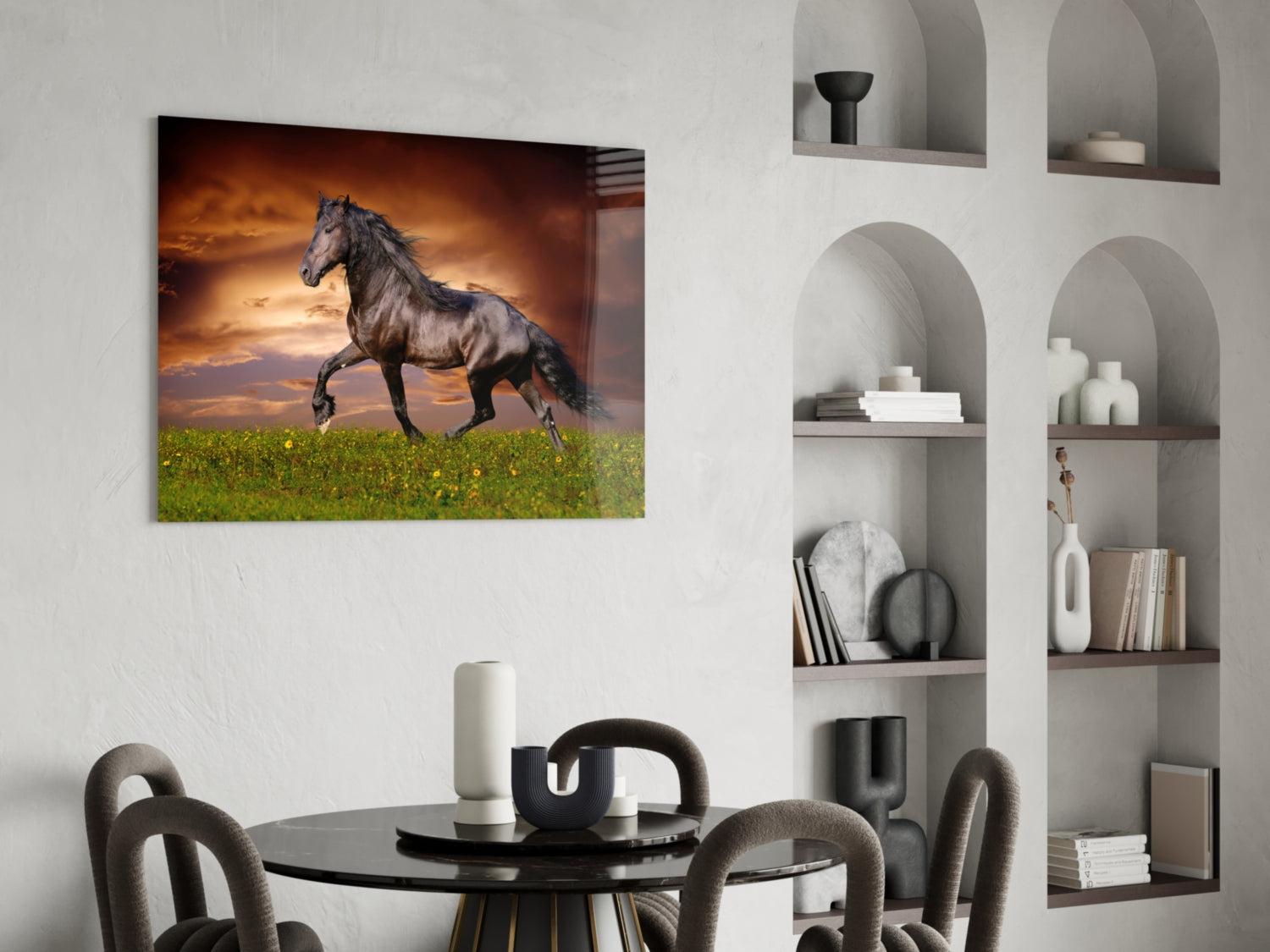 Black horse trotting through green field beneath golden sunset sky on glass wall art displayed above dining table.