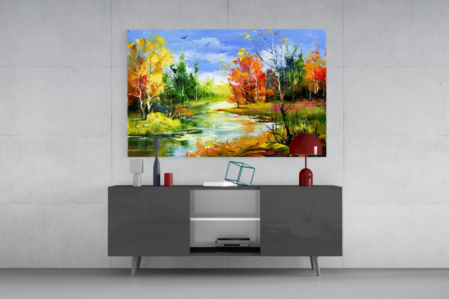 Colorful autumn landscape glass art displayed above a dark gray media console with decorative accessories in a modern living room setting.