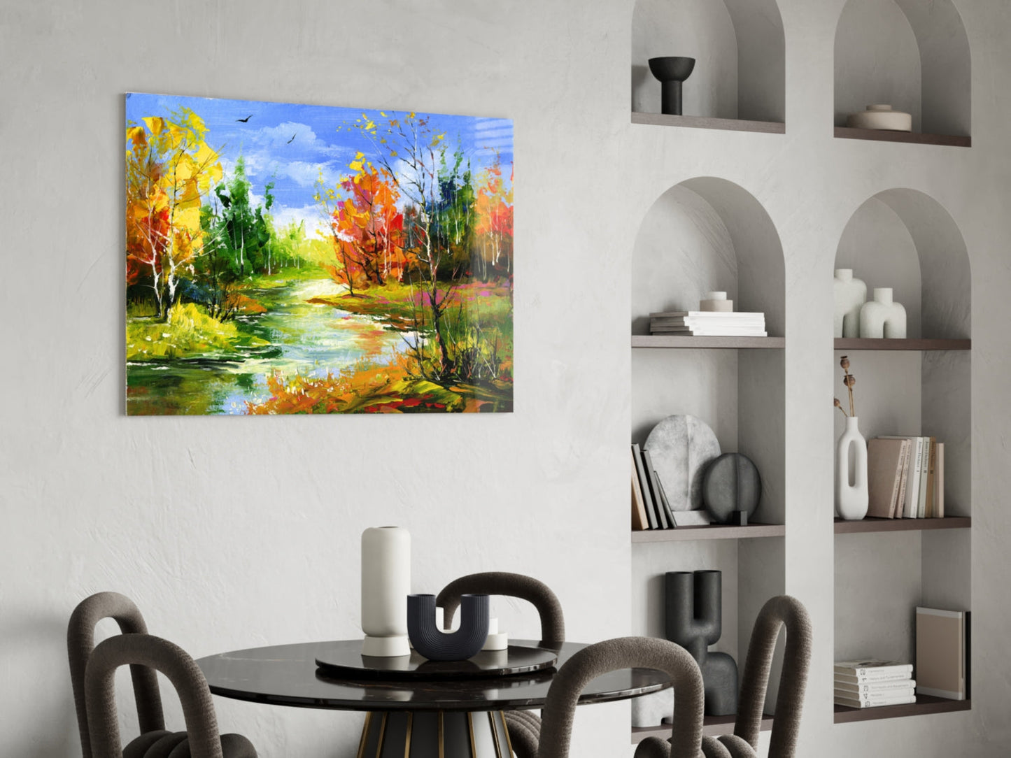 Colorful autumn landscape glass wall art depicting a river with fall foliage displayed above a modern dining table.