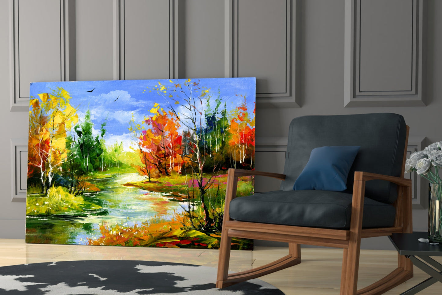 Colorful autumn landscape glass art leaning against wall beside wooden rocking chair in modern interior.