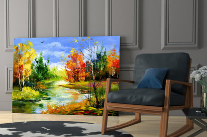 Colorful autumn landscape glass art leaning against wall beside wooden rocking chair in modern interior.