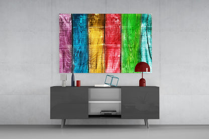 Colorful glass wood wall art with six vertical stripes in pink, blue, yellow, red, green, and turquoise displayed above a dark gray media console.