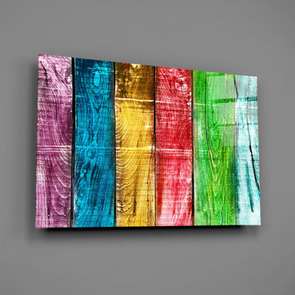 Angled perspective of colorful wood-textured glass wall art displaying six vertical panels in pink, blue, gold, red, green, and white.