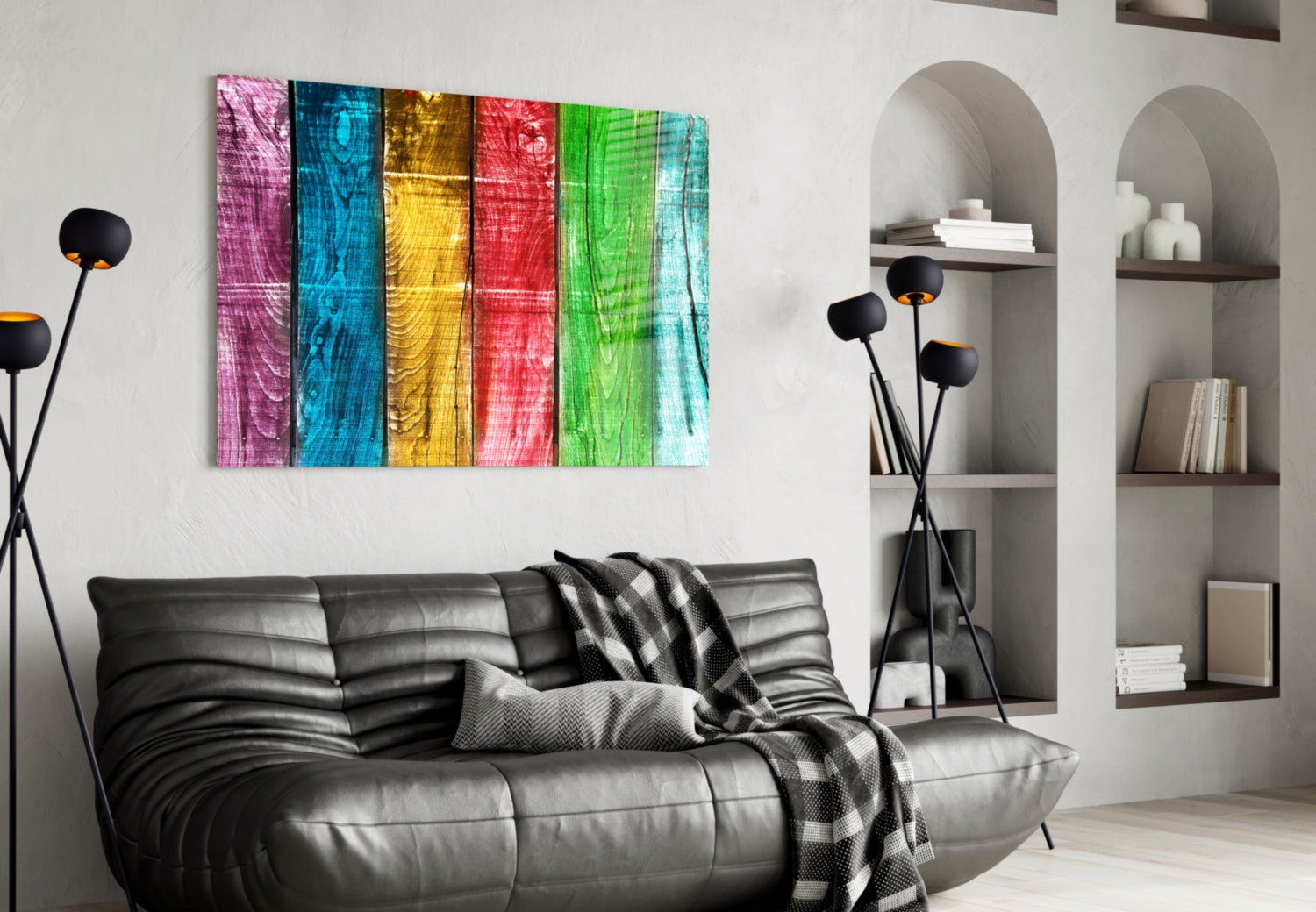 Colorful wood-grain glass wall art with six vertical panels in pink, blue, yellow, red, green, and cyan displayed above a black leather sofa.