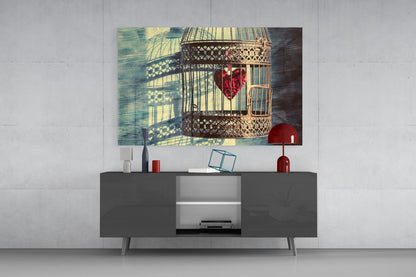 Caged Heart Glass Wall Art displayed above a dark gray media console, showing a decorative birdcage with red flowers and window shadows.