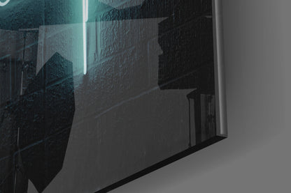 Close-up angled view of frosted glass wall art with turquoise and dark teal printed cityscape and neon light detail.