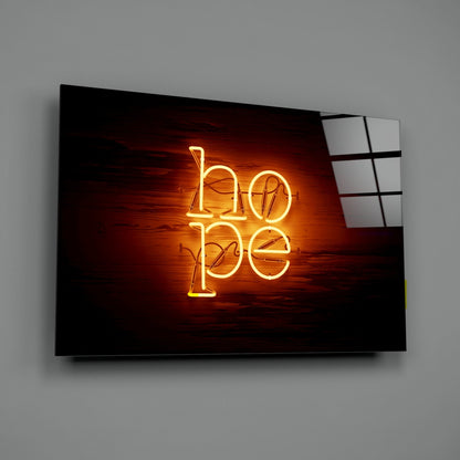 Neon "hope" wall art glowing orange-yellow against dark wooden background, mounted on gray wall at angle.