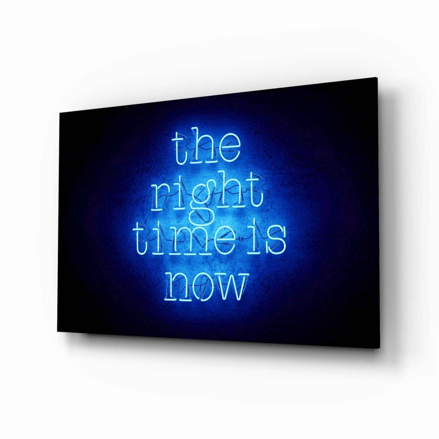 Blue neon text reading "the right time is now" glowing on black glass wall art displayed at an angle.