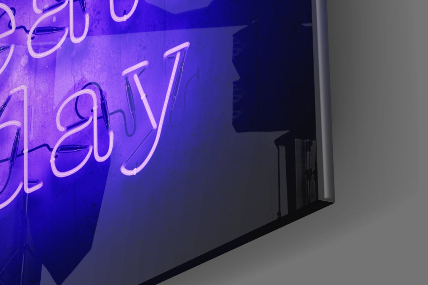 Close-up angled view of neon "Create Today" glass wall art with purple and pink glowing lettering on dark blue background.