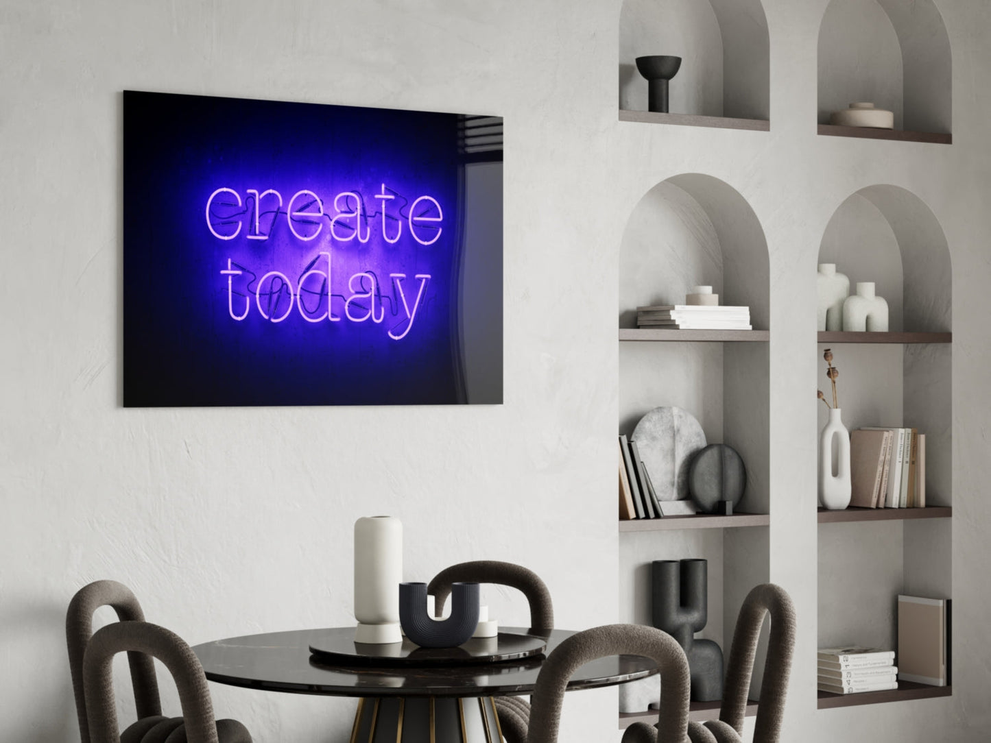 Blue neon "create today" glass wall art mounted above a black round dining table with gray chairs, beside white shelving unit.