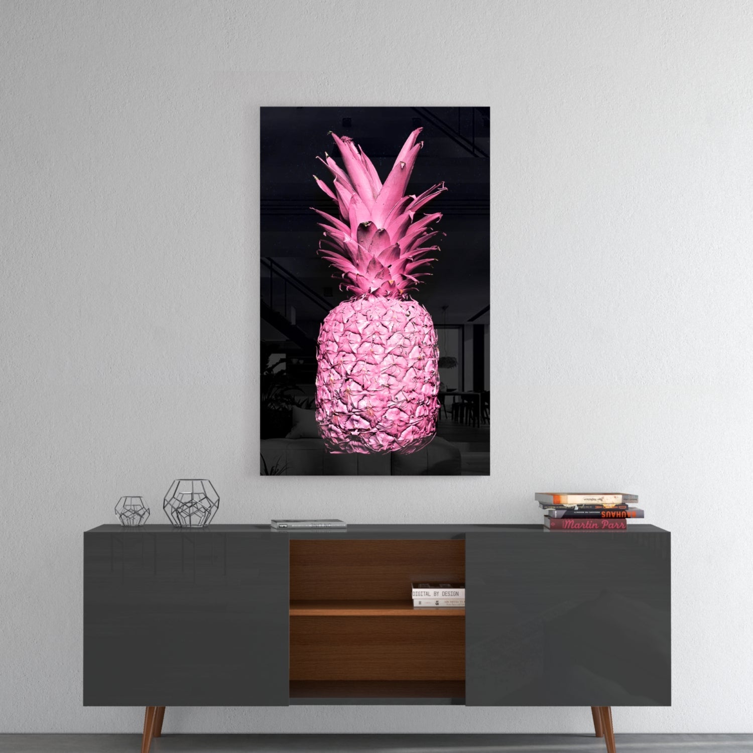 Vibrant pink pineapple glass art displayed on white wall above mid-century modern sideboard with geometric decor.